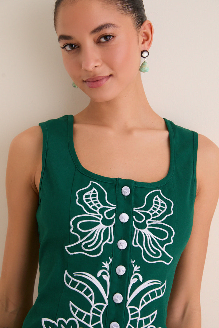 Young woman wearing the Green & Baby Blue Embroidered Lucy Mini Dress, featuring a sleeveless, square neckline with playful embroidery and button details, styled effortlessly with drop earrings.