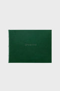 A closed, dark green leather guest book by Graphic Image with "Guests" embossed in uppercase on the front cover.