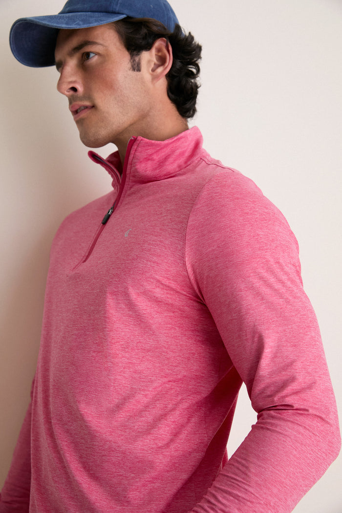 Model in a classic Heathered Red Featherweight Performance Pullover with a stand collar and quarter-zip, exuding effortless, high-end style and fun versatility.