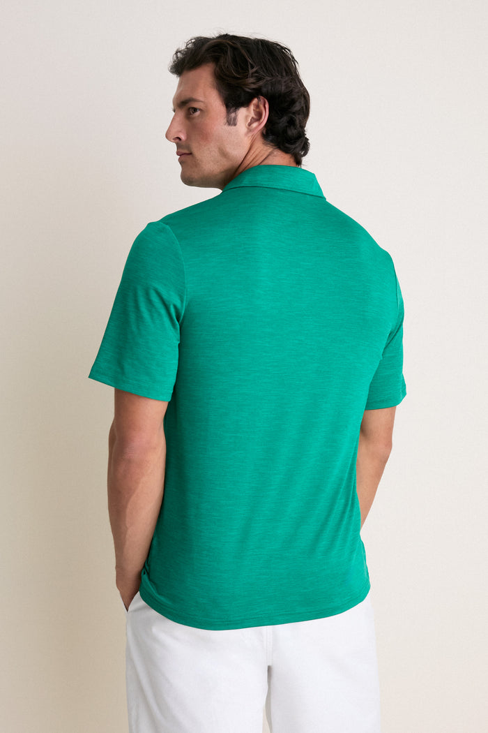 Man in classic, bright-green Home Turf Performance Sport Players Shirt, featuring short sleeves and 4-button placket, embodying effortless style against a simple backdrop.
