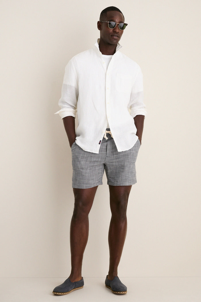 Male model in classic, effortless India Ink Saturday Beach Short, featuring a drawstring waist and subtle texture, exuding laid-back fun and high-end style.