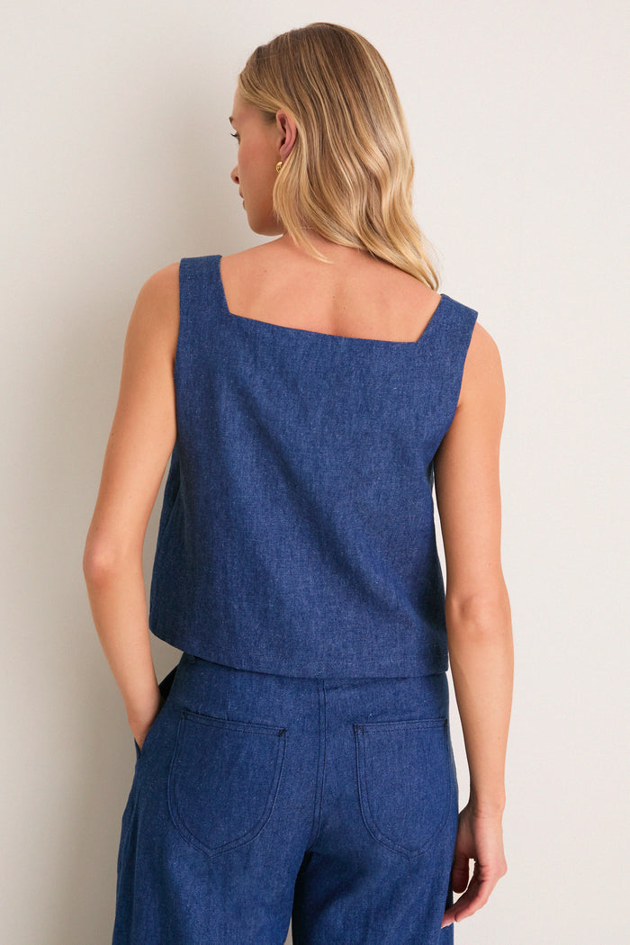 A classic, effortless look: woman in the Indigo Roma Top 2, a chic, sleeveless denim tank with a square neckline, embodying fun and high-end style.