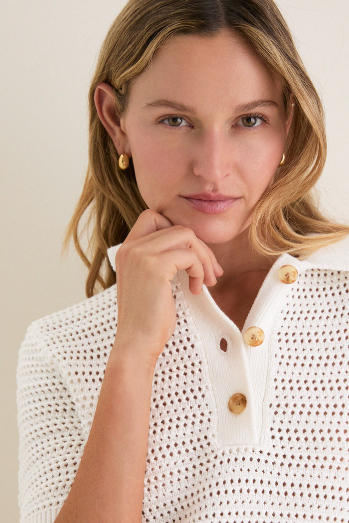 Young woman wears the Ivory Crochet Cotton Asher Polo, an effortlessly classic knitwear with a relaxed fit and three-button placket, embodying high-end, fun style.