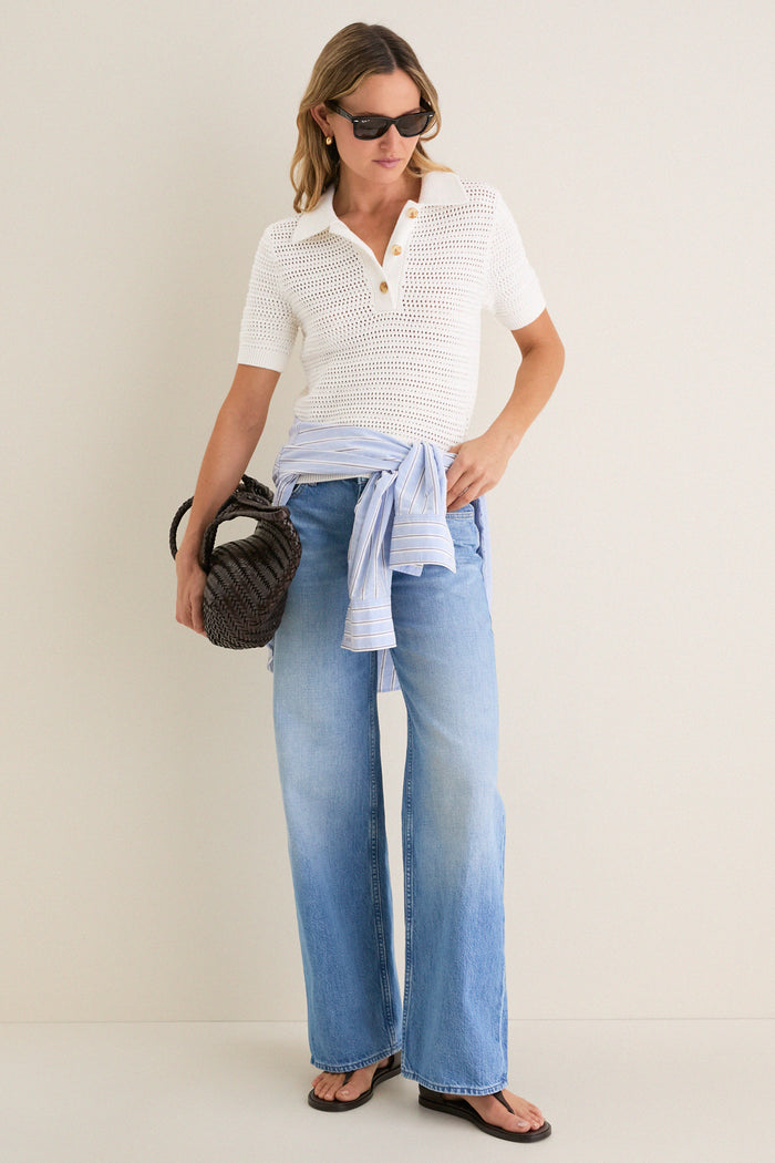 Woman wearing the Ivory Crochet Cotton Asher Polo, a classic, effortless knit top with a relaxed fit, styled with wide-leg jeans, embodying a fun, high-end casual look.