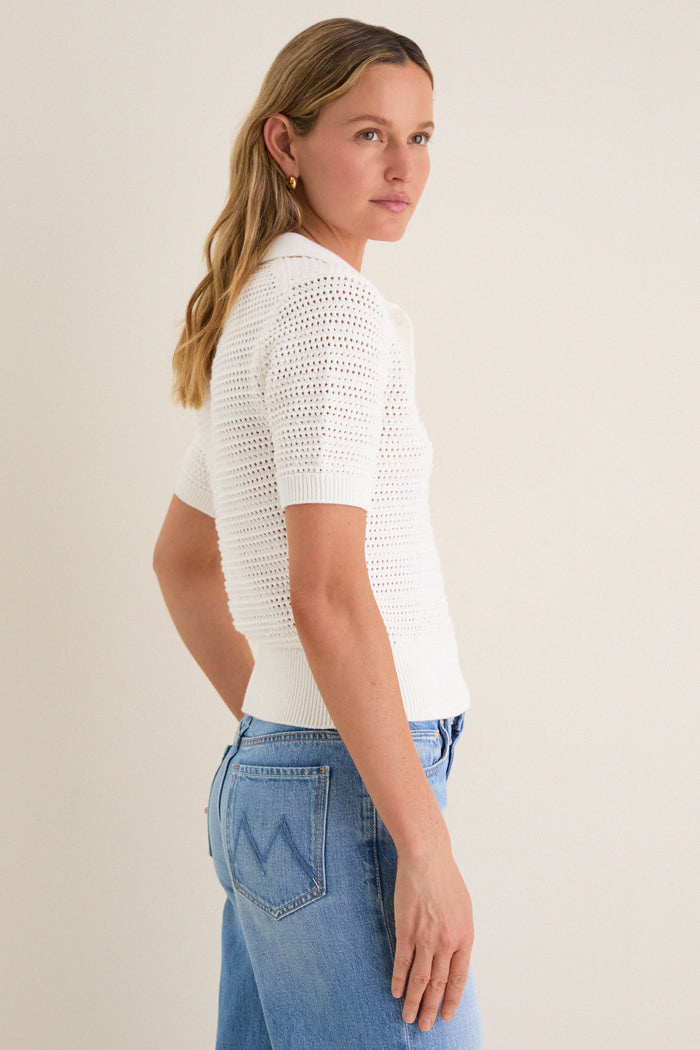 Woman wearing the classic Ivory Crochet Cotton Asher Polo, effortlessly styled with high-waisted jeans, showcasing a fun yet high-end look with a relaxed fit and three-button placket.