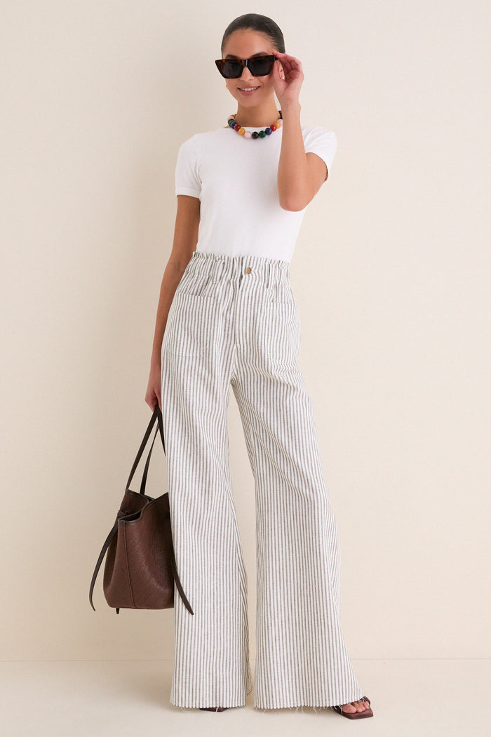 Woman models Juniper Stripe Linen Tulip Wide Leg Pant, showcasing its classic, effortless high-end style. Features include wide leg, elastic waist, and patch pockets, embodying fun coastal ease.