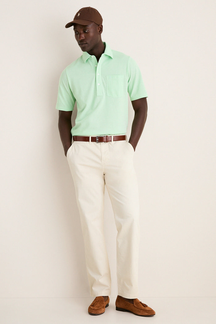 Man in a classic Key West Oxford Pique Players Shirt with chinos and loafers, embodying effortless style and fun, showcasing high-end casual elegance.