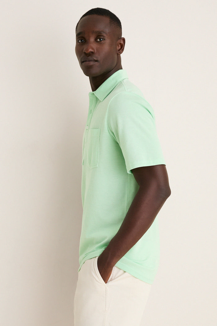 Young man in profile wearing the Key West Oxford Pique Players Shirt, a classic and effortless mint-green polo with a flap pocket, embodying a fun, high-end style.