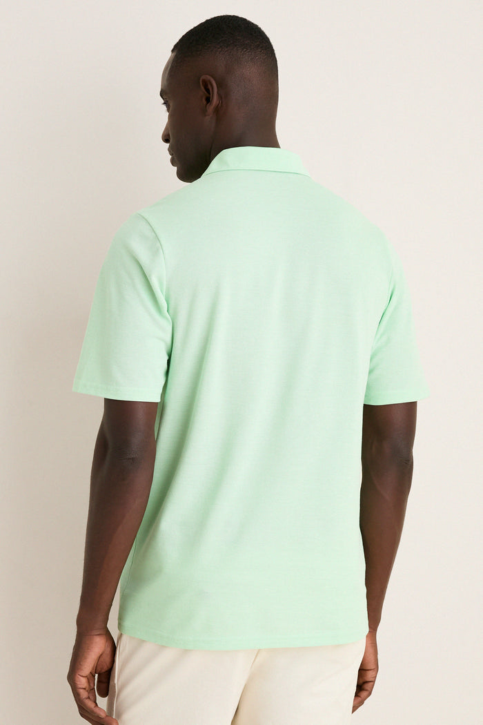 Back view of a man in a Key West Oxford Pique Players Shirt, showcasing its classic, effortless design with a playful hue, flap pocket, and spread collar.