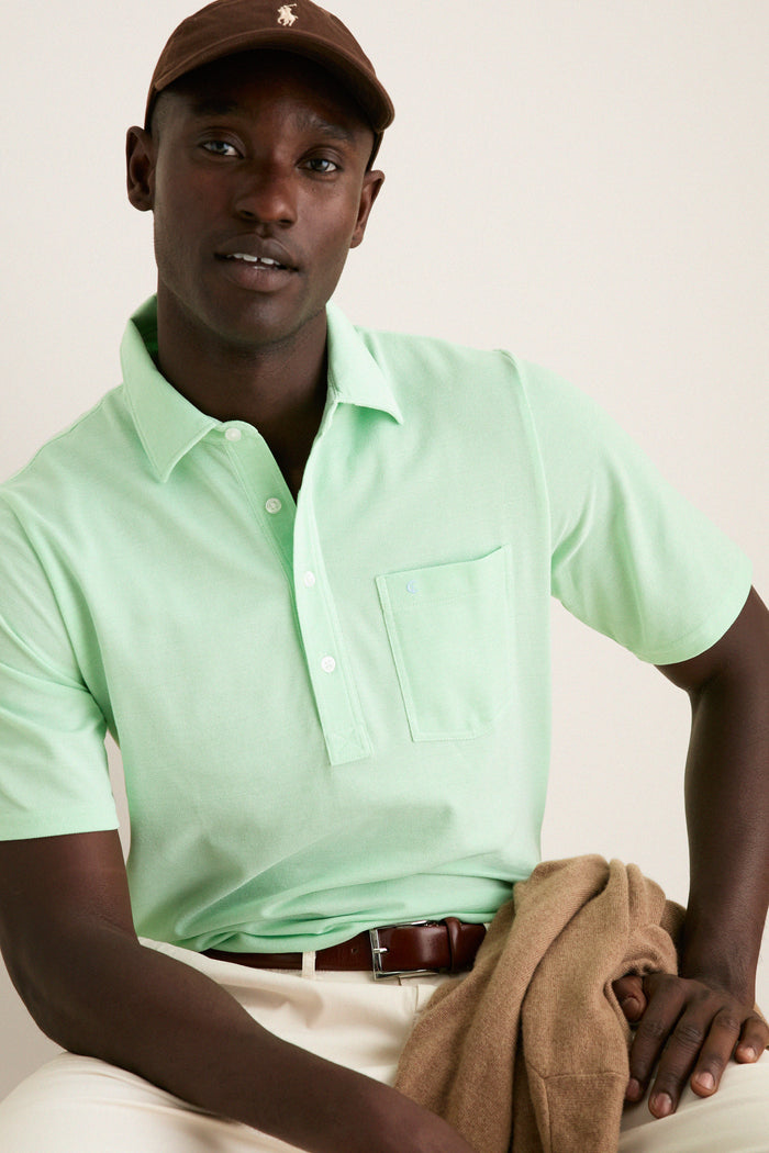 Man wears the classic Key West Oxford Pique Players Shirt, exuding effortless style with its 4-button placket and flap pocket, paired with a casual, high-end look.