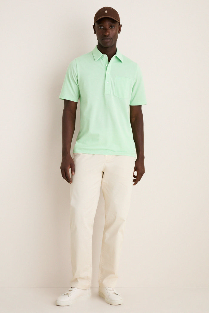 Man wearing the classic Key West Oxford Pique Players Shirt with flap pocket, styled effortlessly with trousers and a cap, embodying a fun, high-end look.
