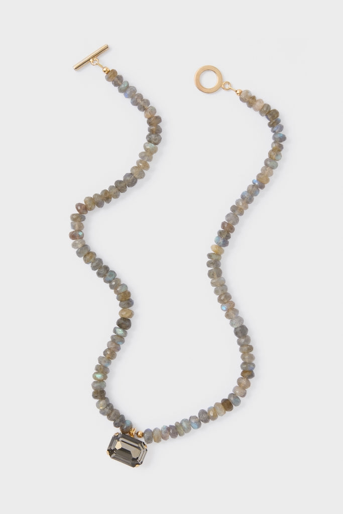 Labradorite Sidonie Necklace: A classic, high-end piece featuring faceted grey-blue labradorite beads and a smokey-grey stone in a gold-tone setting, offering effortless elegance and fun style.