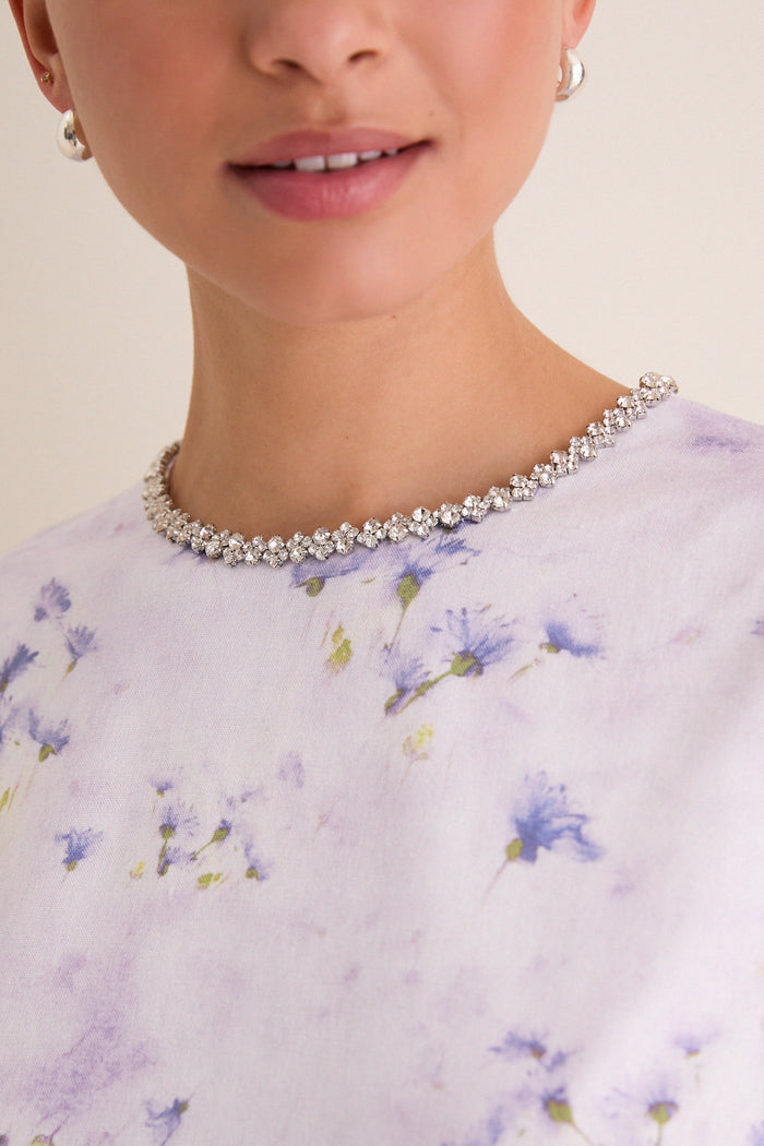 Close-up of a classic, sparkly tennis necklace complementing the Lilac Floral Crystal Embellished Floria Mini Dress with a fun, effortless, high-end vibe.