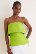 Young Black woman wearing a classic, lime Felix Satin Strapless Top with fold-over neckline, styled effortlessly with white pants and gold accessories, embodying high-end, fun fashion.