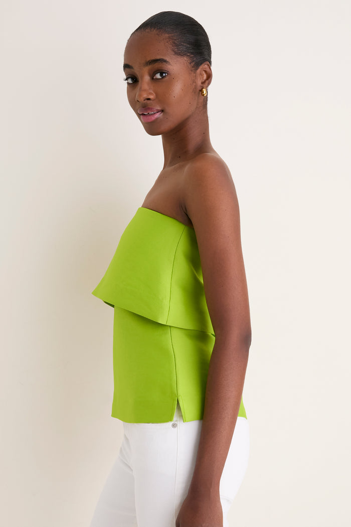 Young woman in profile wearing the Lime Felix Satin Strapless Top, featuring a fold-over neckline, paired with white pants. Effortless, high-end style with classic elegance.