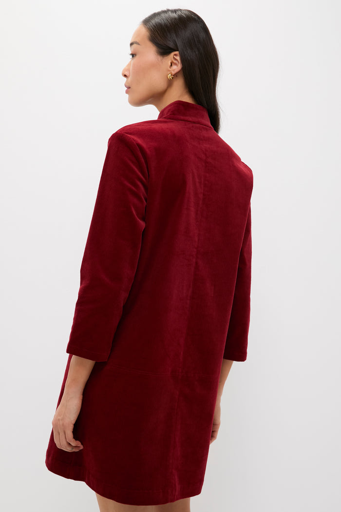 Woman in Merlot Corduroy Clifton Dress, a classic Tuckernuck piece with three-quarter sleeves and V-neckline, exuding effortless style and high-end versatility.
