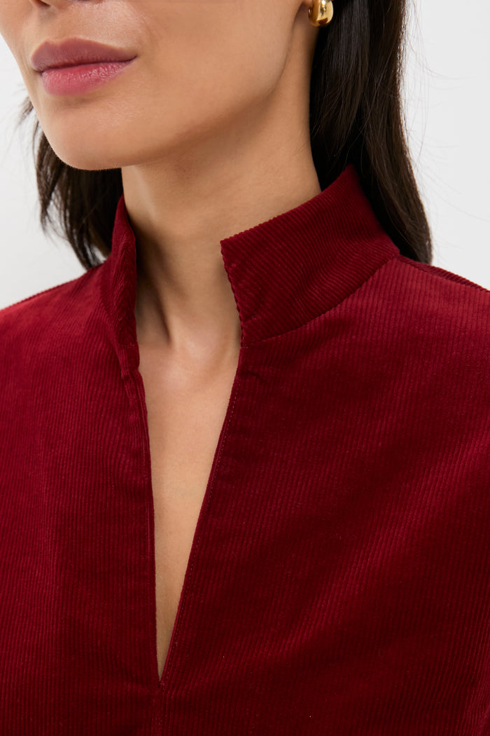 Close-up of a woman wearing the Merlot Corduroy Clifton Dress, showcasing its classic stand collar and V-neckline for an effortlessly chic, high-end look.