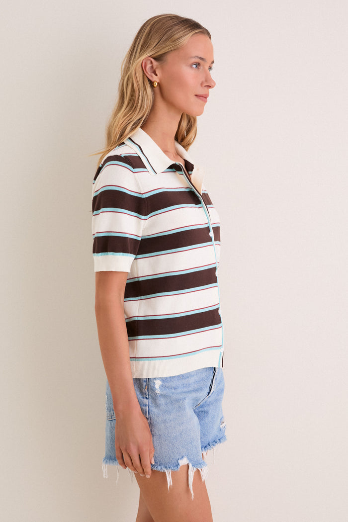 Young woman in a Mint Chocolate Stripe Reid Polo Cardigan with button-front, short sleeves, and collared neckline, paired with denim shorts, exuding classic, effortless style.