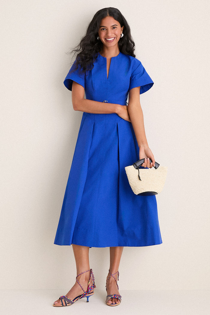 Woman in a classic cobalt-blue dress wearing Miro Aitana Wrap Heels, showcasing effortless style with fun, multicolored braided straps and a high-end look.