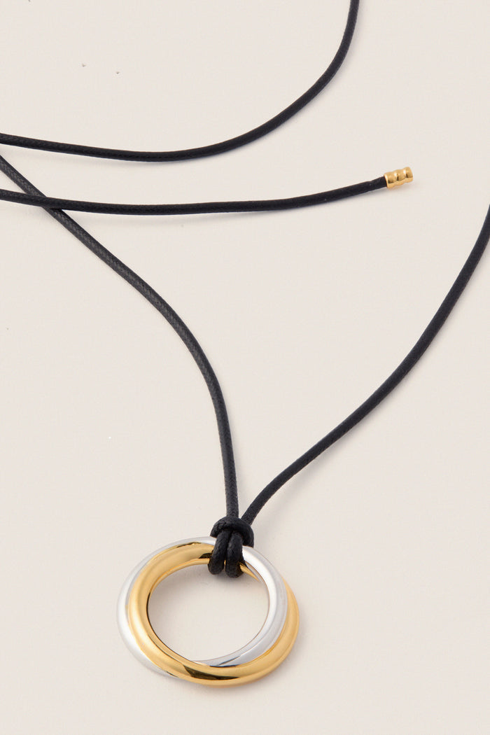 Mixed Lucy Williams Entwine Pendant Cord Necklace features interlocking gold and silver rings on an adjustable black cord, offering a classic, effortless, and high-end touch to any outfit.