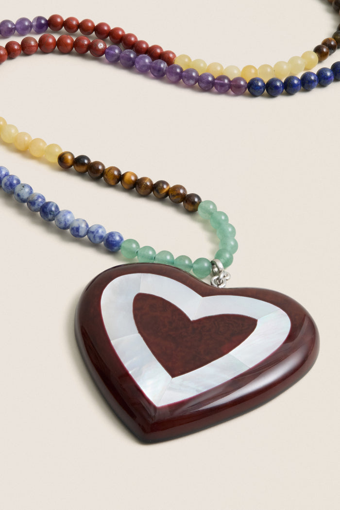 Multi Alma Necklace featuring vibrant semi-precious beads and a classic heart pendant with reddish-brown center and mother-of-pearl inlay; effortlessly fun and high-end design.