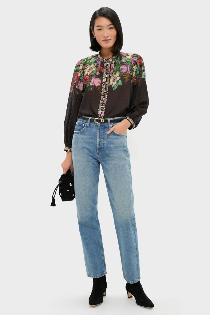 Woman models the classic, high-end Multi Viktoria Print Long Sleeve Blouse with effortless floral elegance. Paired with jeans and boots, it embodies fun and modern femininity.