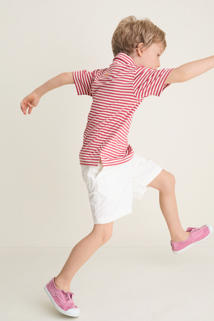 Young child wearing the classic Nantucket Red and Creme Le Club Polo, showcasing its effortless, high-end style as he joyfully runs, embodying fun and comfort.