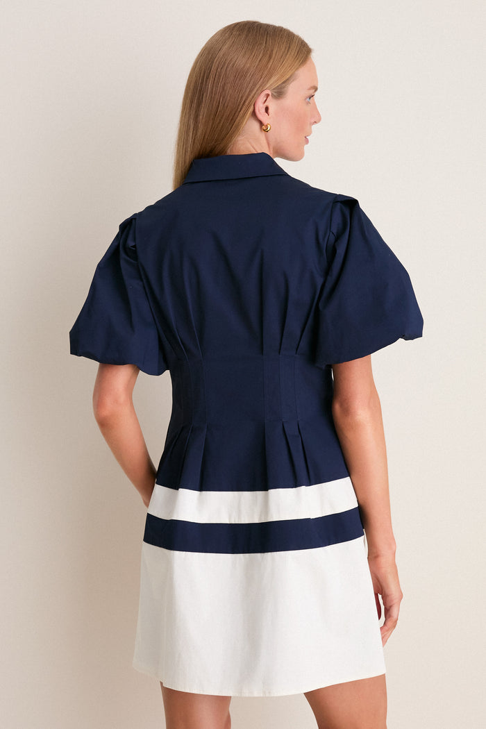 Woman wearing the classic Navy and White Stripe Mini Delaney Dress, showcasing an effortless, fun, high-end style with a tapered waist and collared design.