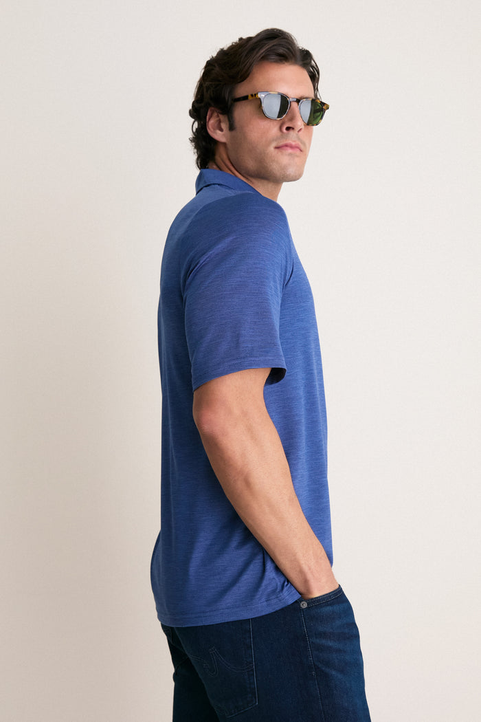 Young man wearing the Navy Captain Heather Performance Sport Players Shirt, a classic polo with a chest pocket and tortoiseshell sunglasses, embodying effortless, high-end style.