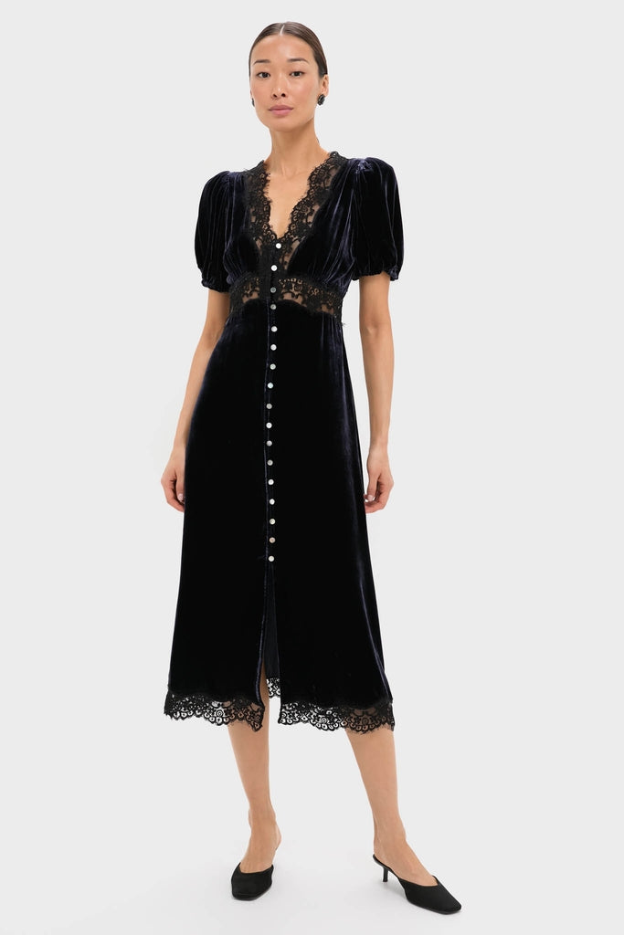 Woman modeling the Navy Clarice Velvet Puff Sleeve Midi Dress, featuring a classic deep V-neckline, lace-trimmed waist, and an effortless high-end style.