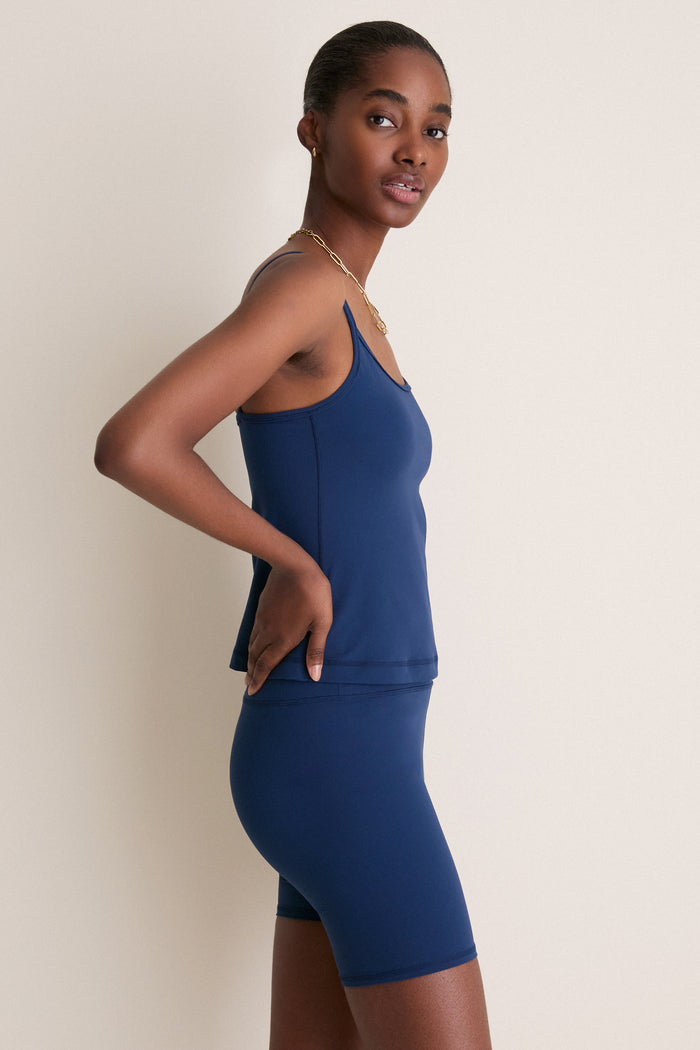 Young woman in profile wears the classic, high-end Navy Compression Spandex Sofia Cami, showcasing its effortless style and functional design with adjustable straps and a built-in shelf bra.
