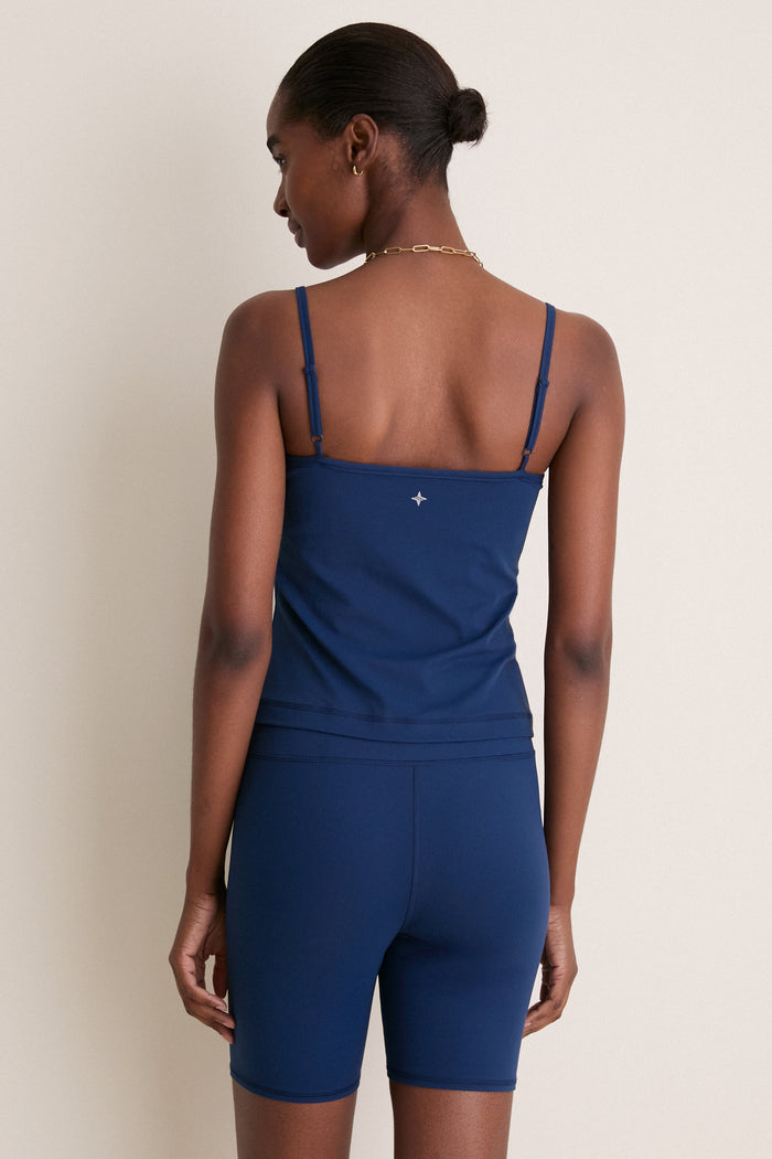 Woman wearing classic Navy Compression Spandex Sofia Cami with adjustable straps, built-in shelf bra, and compression fabric, embodying effortless style and high-end comfort.