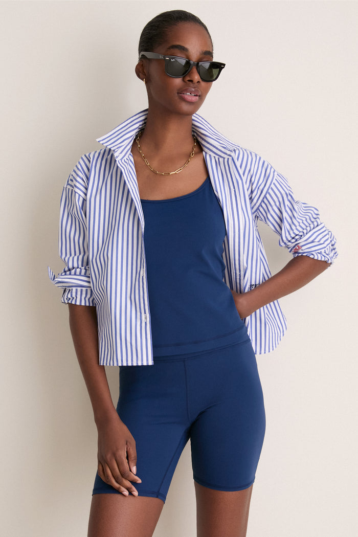 Model wearing the Navy Compression Spandex Sofia Cami with a classic round neckline and adjustable straps, effortlessly layered under a striped shirt for a fun, high-end look.