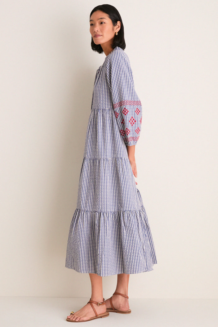 Woman in profile wearing the Navy Prism Embroidered Gingham Long Sleeve Salty Paloma Caftan, a classic, effortless, and high-end Tuckernuck piece with fun embroidered details.