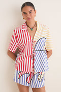 Young woman in a classic, effortless Navy Stripes Off-White Tie Front Blouse with playful multi-colored stripes, embodying high-end, fun style.