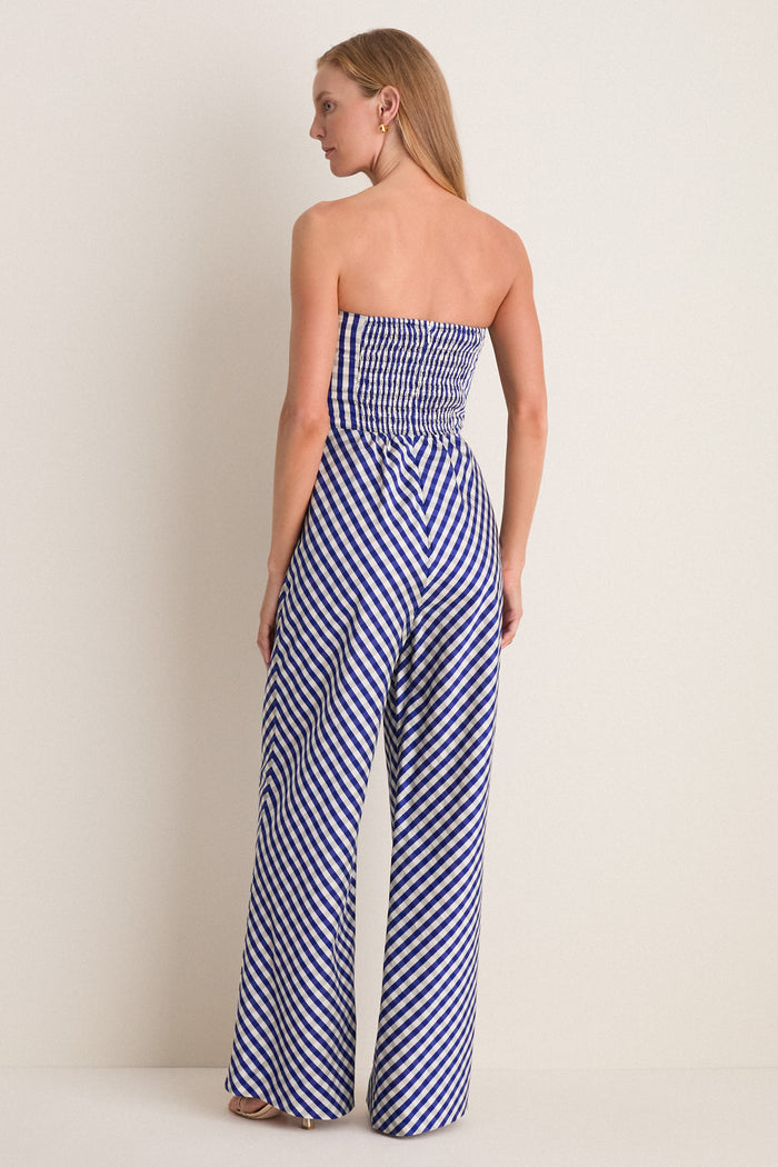 Ocean Gingham Kat Jumpsuit, classic and effortless, features a shirred bodice, wide-leg pants, and a playful oversized bow, embodying high-end, fun style.