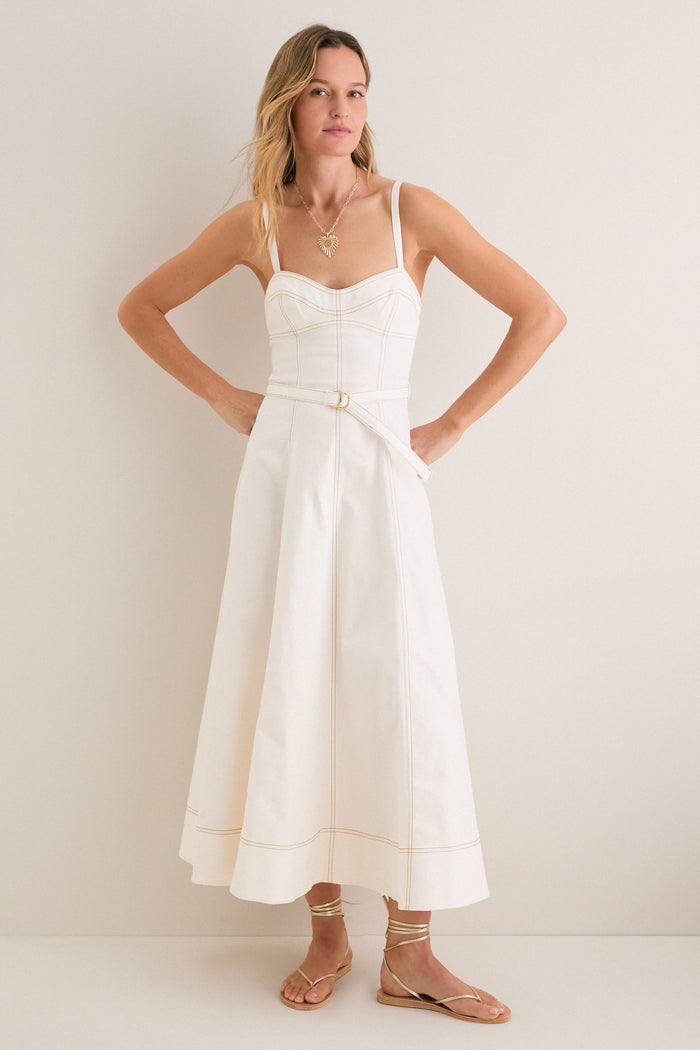 Woman in the Off White Fiona Dress, a classic sleeveless midi with a fitted bodice and flared skirt, styled effortlessly with gold sandals and necklace.