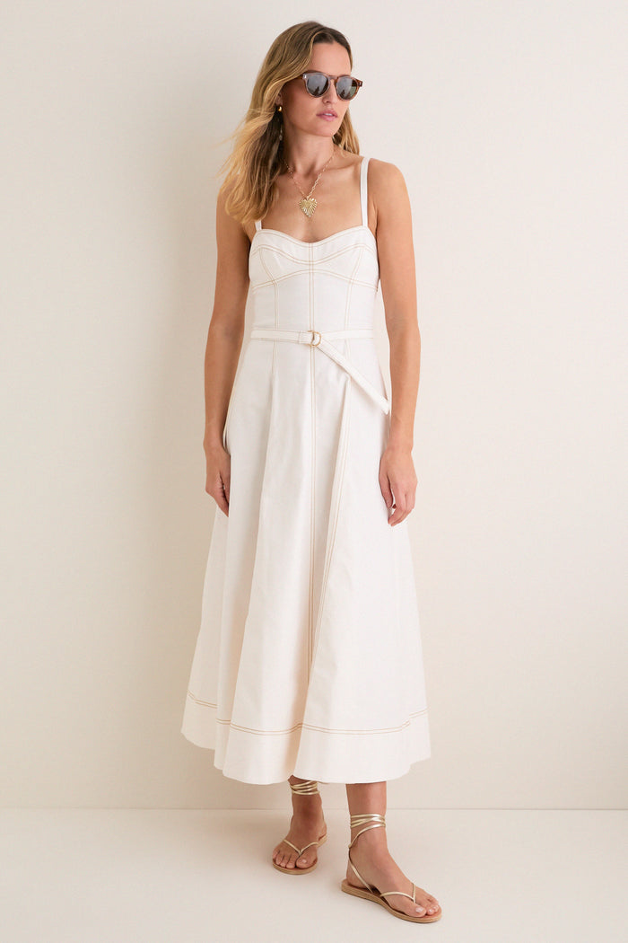 Woman in an Off White Fiona Dress, featuring a classic, effortless design with a fitted bodice and flared skirt, accessorized with fun, high-end gold jewelry and sandals.