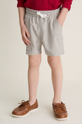 Child wearing classic Patagonian Putty Le Club Shorts with elastic waist and white drawstring; paired with boat shoes, capturing an effortless, high-end, and fun style for warm-weather adventures.