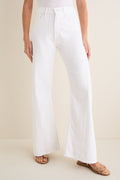 Person wearing Pinch of Salt The Lemon Twist Skimp high-waisted, wide-leg jeans with tan flat sandals, exuding a classic, effortless style on a neutral backdrop.