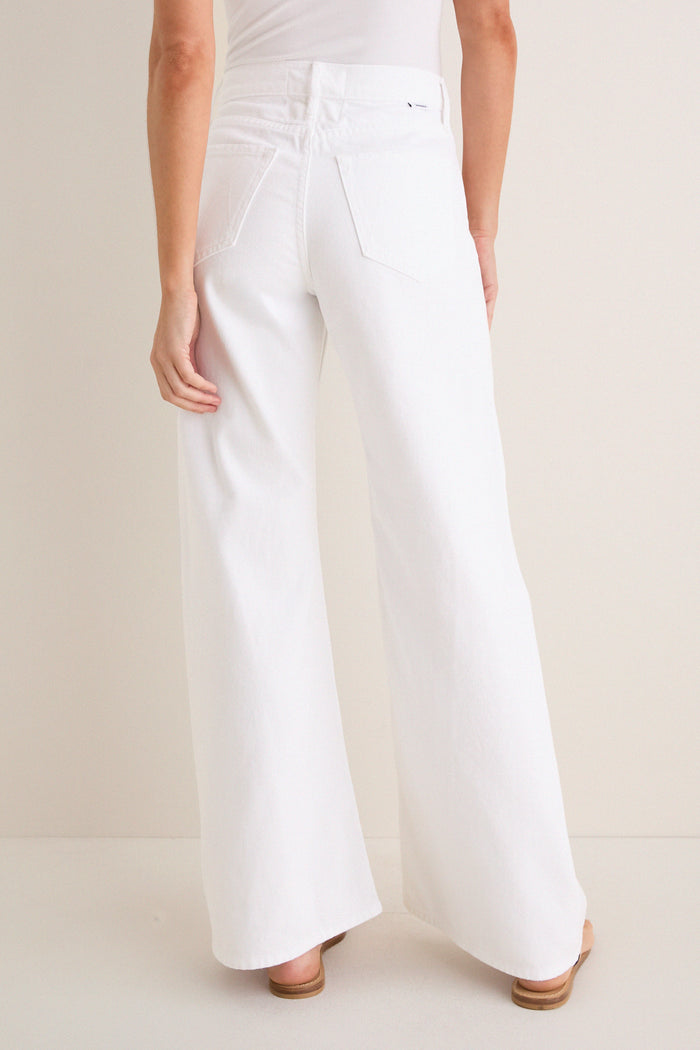Back view of Pinch of Salt The Lemon Twist Skimp, featuring high-waisted, wide-leg white pants with rear pockets, embodying a classic, effortless style with high-end appeal.