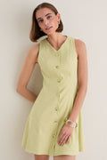 Young woman in a classic, effortless Pistachio Steiner Dress, showcasing its high-end A-line silhouette and button-down design, embodying fun and sophistication.