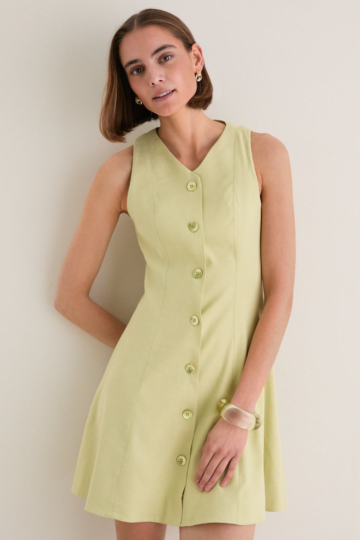 Young woman in a classic, effortless Pistachio Steiner Dress, showcasing its high-end A-line silhouette and button-down design, embodying fun and sophistication.