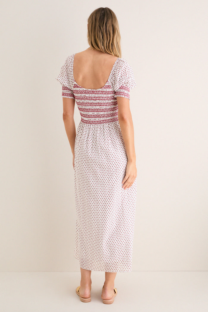 Model wearing the classic Poppy Half Drop White Madeline Nap Dress with a scooped back, flutter sleeves, and smocked bodice, embodying effortless, high-end style.