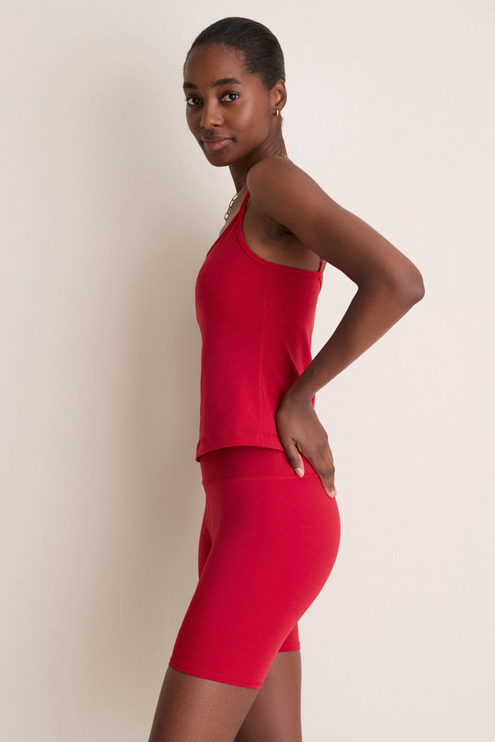 Red Compression Spandex Sofia Cami worn by woman with classic style, featuring adjustable straps and built-in shelf bra, effortlessly blending fun and high-end activewear aesthetics.