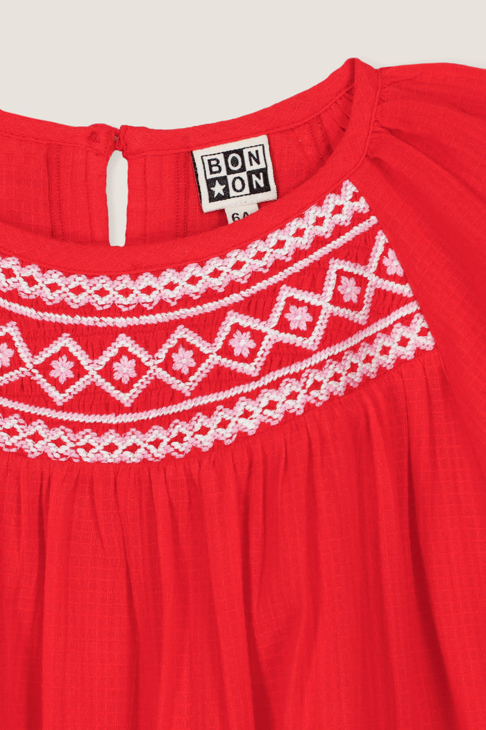 Red Nala Dress: A classic, effortless children’s outfit featuring a gathered neckline, white embroidery, and keyhole closure, perfect for a fun, high-end look.