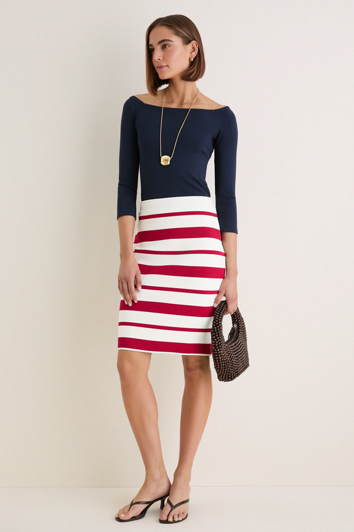 Woman in Ruby Knit Stripe Milo Pencil Skirt, high-waisted with bold stripes, embodying a classic yet fun and effortless high-end style.