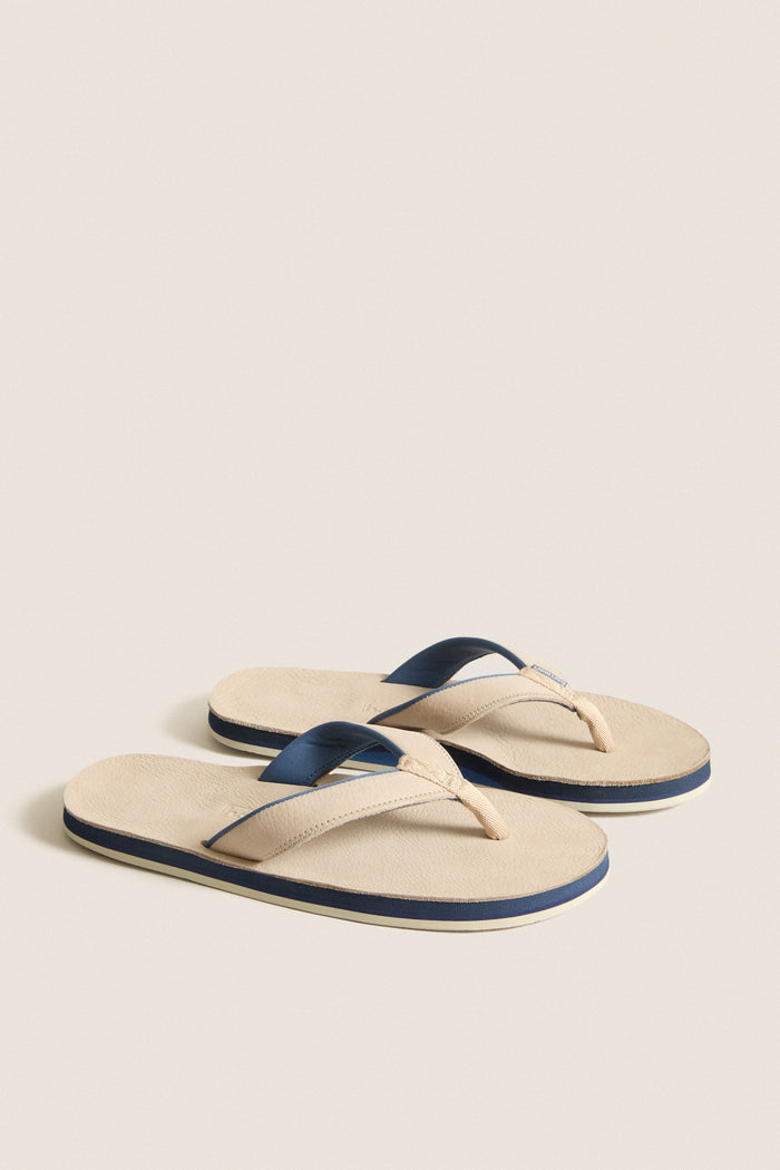 Sand Pier Pebbled Leather Sandal exudes classic style with effortless comfort, featuring navy-accented straps and a memory foam toe post for a fun, high-end look.