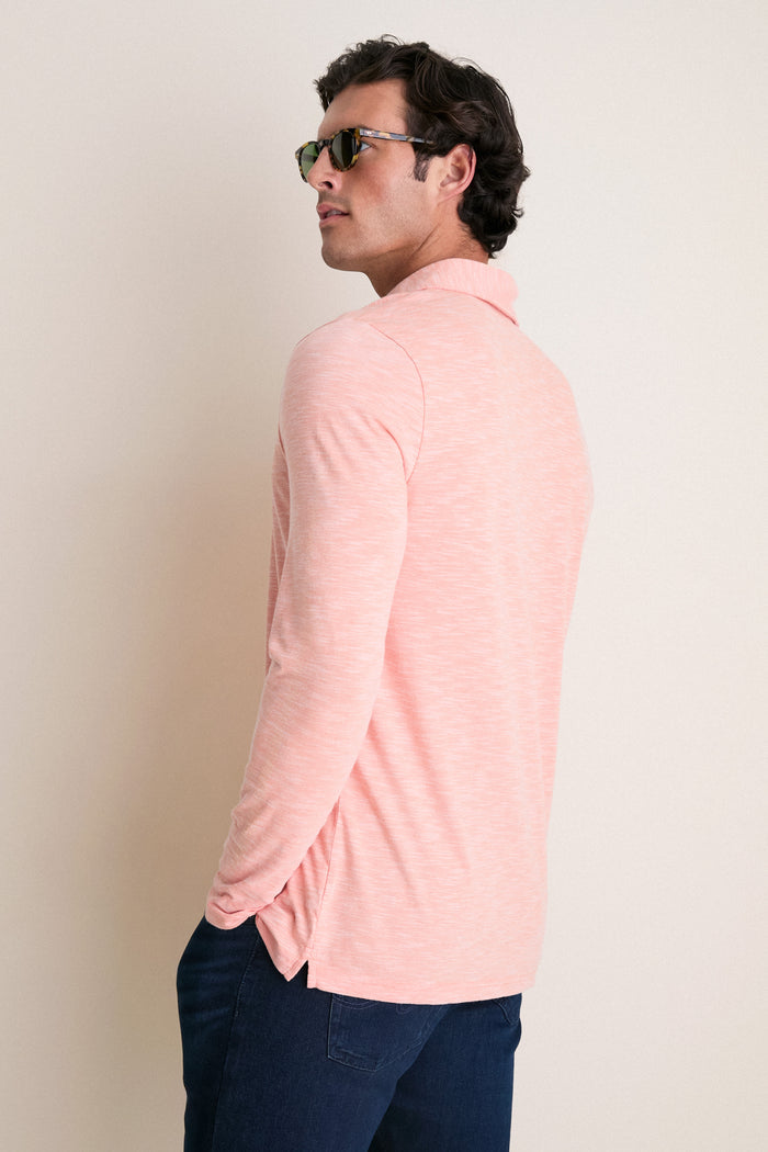 Man in tortoiseshell sunglasses models classic Shell Phone Brrr Long Sleeve Range Polo, showcasing its effortless style and high-end cooling technology against a neutral backdrop.