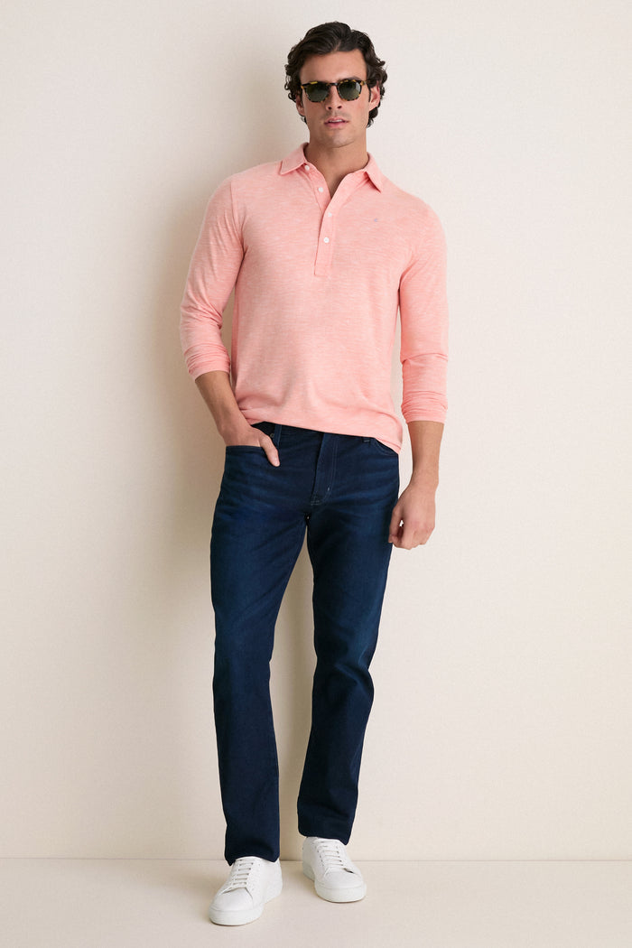 Man wearing classic, effortless Shell Phone Brrr Long Sleeve Range Polo with high-end cooling technology, paired with dark jeans and white sneakers, exuding a fun, confident style.